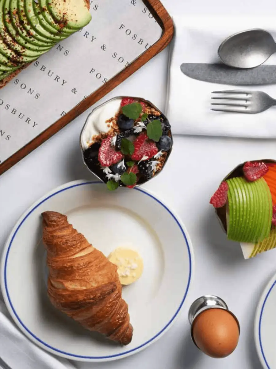 Breakfast at Fosbury & Sons: avocado toast, a croissant, a yoghurt and berry bowl, and a boiled egg